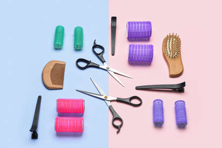 Set of different hairdresser's tools and hair curlers on color backgroundの写真素材