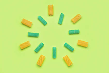 Frame made of different hair curlers on green backgroundの写真素材