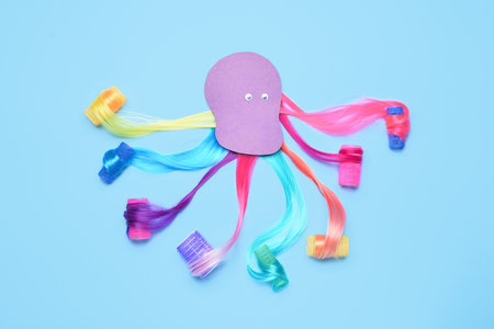 Octopus made of different hair strands and curlers on color backgroundの写真素材