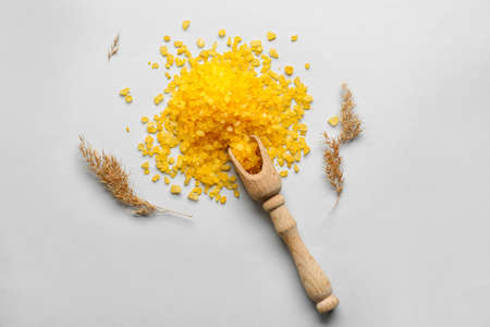 Composition with wooden scoop of orange sea salt and pampas grass on white backgroundの写真素材