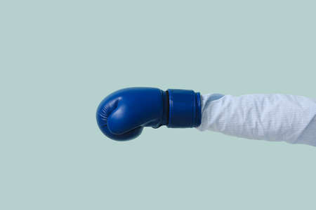 Hand in boxing glove on color backgroundの写真素材