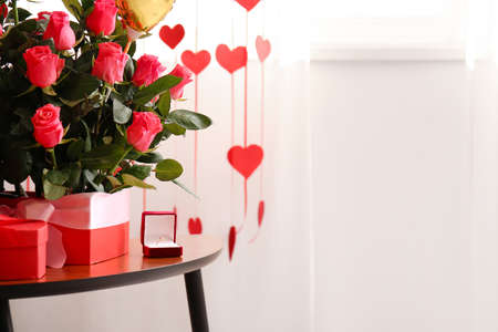 Boxes with beautiful roses and engagement ring on table in room. Valentine's Day celebrationの写真素材