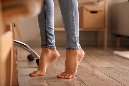 Bare feet of young woman at home, closeup