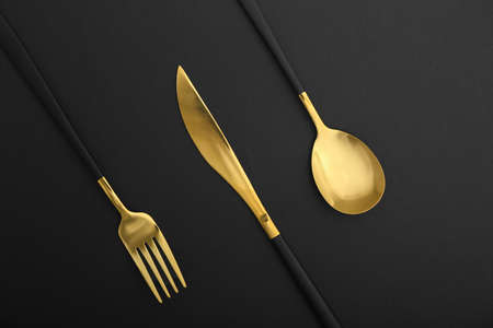 Set of stainless steel cutlery with black handle on black background, closeupの写真素材