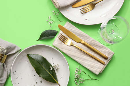 Elegant table setting with floral decor on green backgroundの写真素材