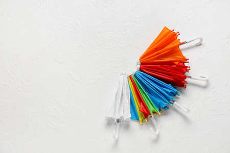 Set of colorful mini umbrellas on light background