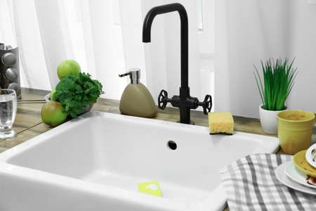 Sink with sponge for dish washing and dirty dishware on counterの写真素材