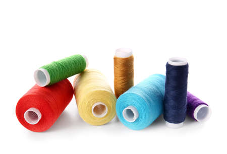Different sewing thread spools on white background