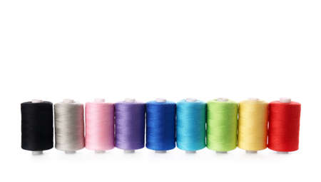 Different sewing thread spools on white background