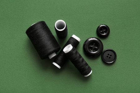 Thread spools and buttons on green background