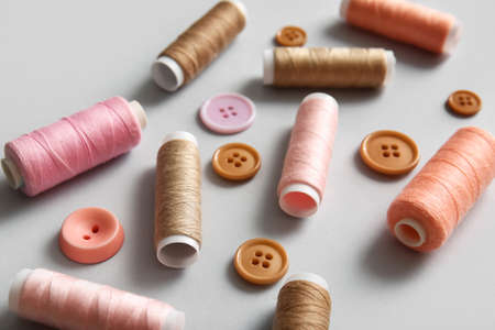 Thread spools and buttons on light backgroundの写真素材
