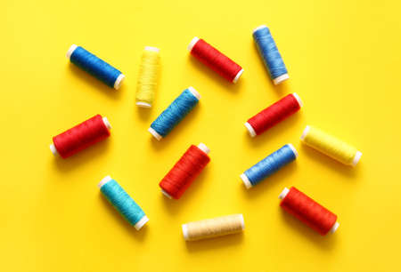 Thread spools on yellow background