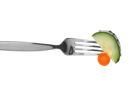 Fork with cucumber and carrot slices on white backgroundの写真素材