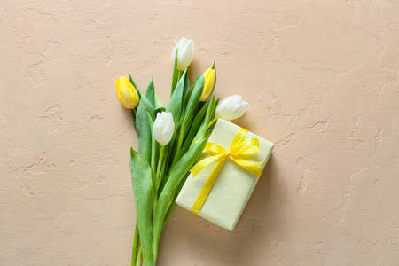 Beautiful tulip flowers and gift box for International Women's Day on beige backgroundの写真素材