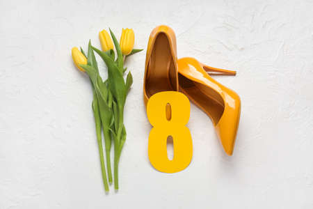Stylish female shoes, tulips and paper figure 8 on light background