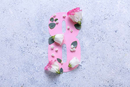 Composition with paper figure 8 and flowers on light background