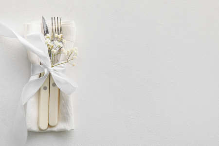 Elegant cutlery and flowers on light backgroundの写真素材