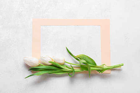 Composition with paper frame and tulip flowers on light backgroundの写真素材