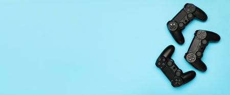 Modern game pads on light blue background with space for text