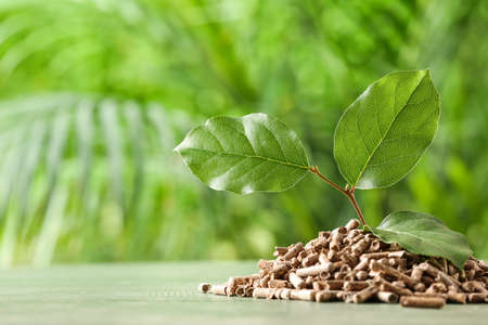 Pile of wood pellets on table outdoors, closeup