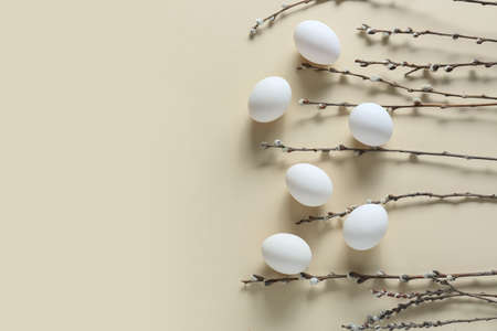 Easter eggs and pussy willow branches on beige background