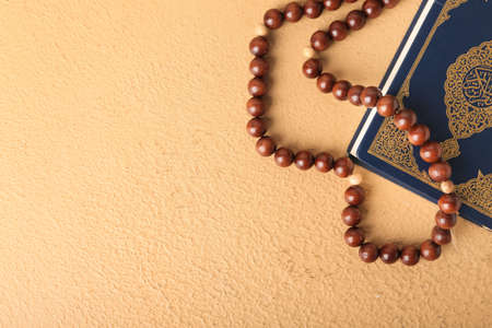 Koran and Muslim prayer beads on color backgroundの写真素材