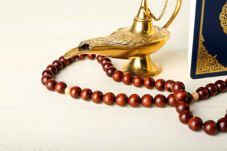 Koran, lamp and Muslim prayer beads on white wooden backgroundの写真素材
