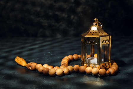 Muslim lamp and prayer beads on dark background