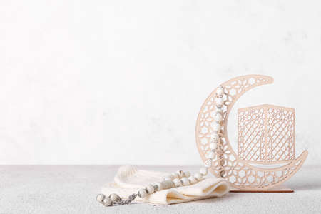 Decorative crescent, hat and Muslim prayer beads on light backgroundの写真素材
