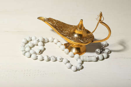 Lamp and Muslim prayer beads on light backgroundの写真素材