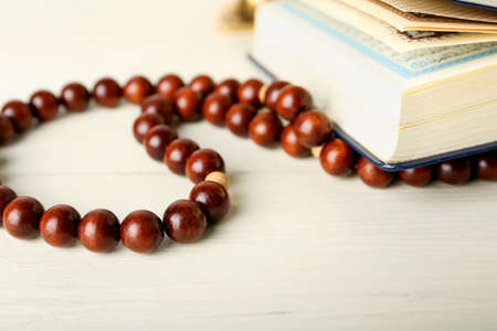 Koran and Muslim prayer beads on table, closeup