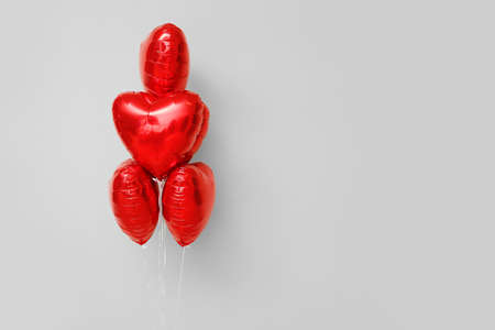 Beautiful heart-shaped balloons for Valentine's Day celebration on color backgroundの写真素材