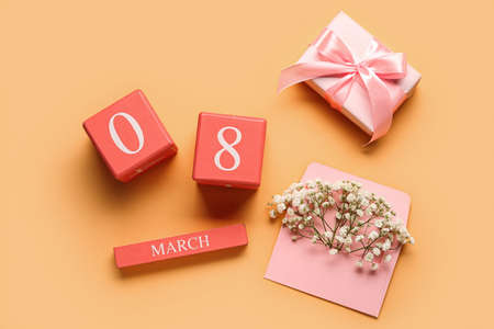 Cube calendar with date MARCH 8, gift box and gypsophila flowers for International Women's Day celebration on color backgroundの写真素材