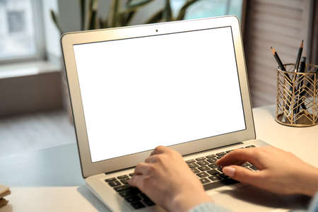 Woman working with modern laptop on light table, closeup