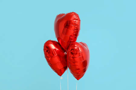 Beautiful heart-shaped balloons for Valentine's Day celebration on blue background