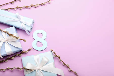 Composition with paper figure 8, willow branches and gift boxes for International Women's Day celebration on violet backgroundの写真素材