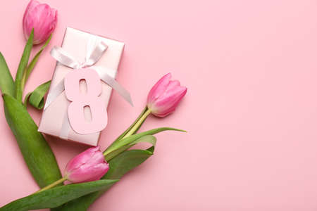 Composition with figure 8, tulips and gift box for International Women's Day celebration on pink backgroundの写真素材