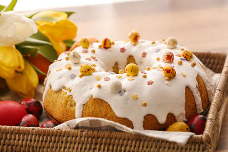 Tasty Easter cake and eggs in basket