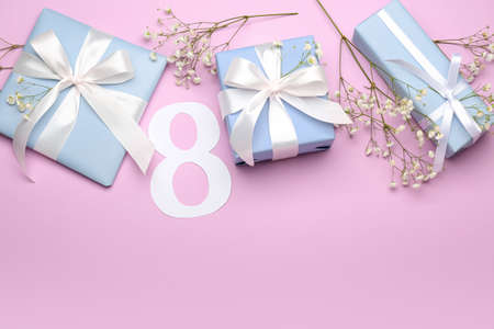 Composition with figure 8, gypsophila flowers and gift boxes for International Women's Day...