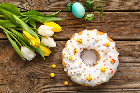 Tasty Easter cake, tulip flowers and eggs on wooden backgroundの写真素材