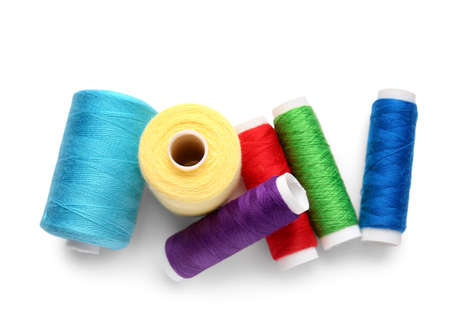 Different thread spools on white background