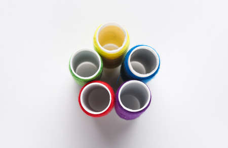 Different thread spools on white background