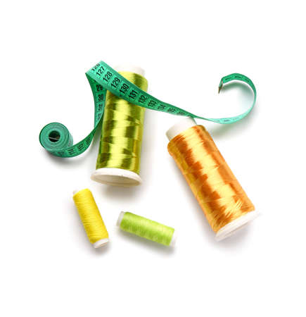 Thread spools with measuring tape on white background