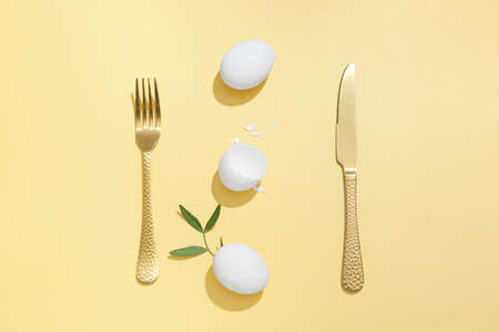 Beautiful Easter composition with eggs and cutlery on color background