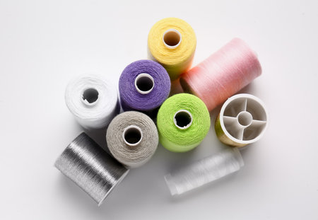 Different thread spools on white background