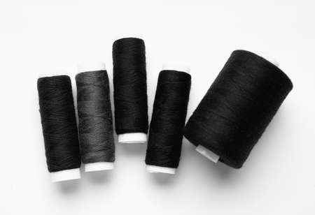 Black thread spools on white backgroundの写真素材