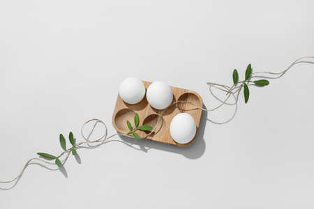 Holder with Easter eggs, rope and tree branches on gray backgroundの写真素材