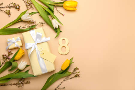 Composition with figure 8, gift boxes and flowers for International Women's Day celebration on color backgroundの写真素材