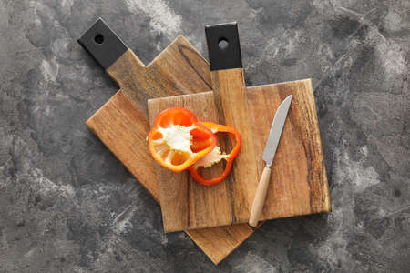 Wooden cutting boards and bell pepper slices on black background