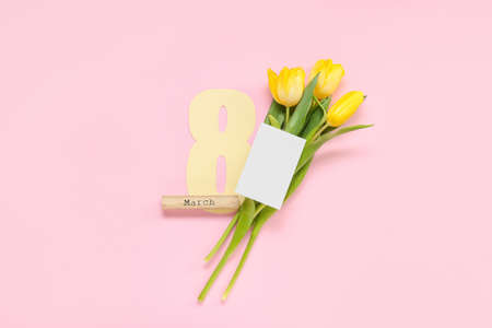 Blank greeting card for International Women's Day, tulips, paper figure 8 and word MARCH on pink...